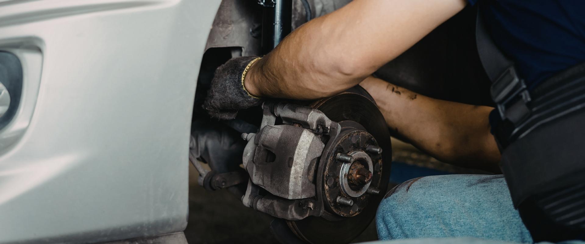 Mecânico fazendo a inspeção de pastilhas de freio gastas e discos de freio.